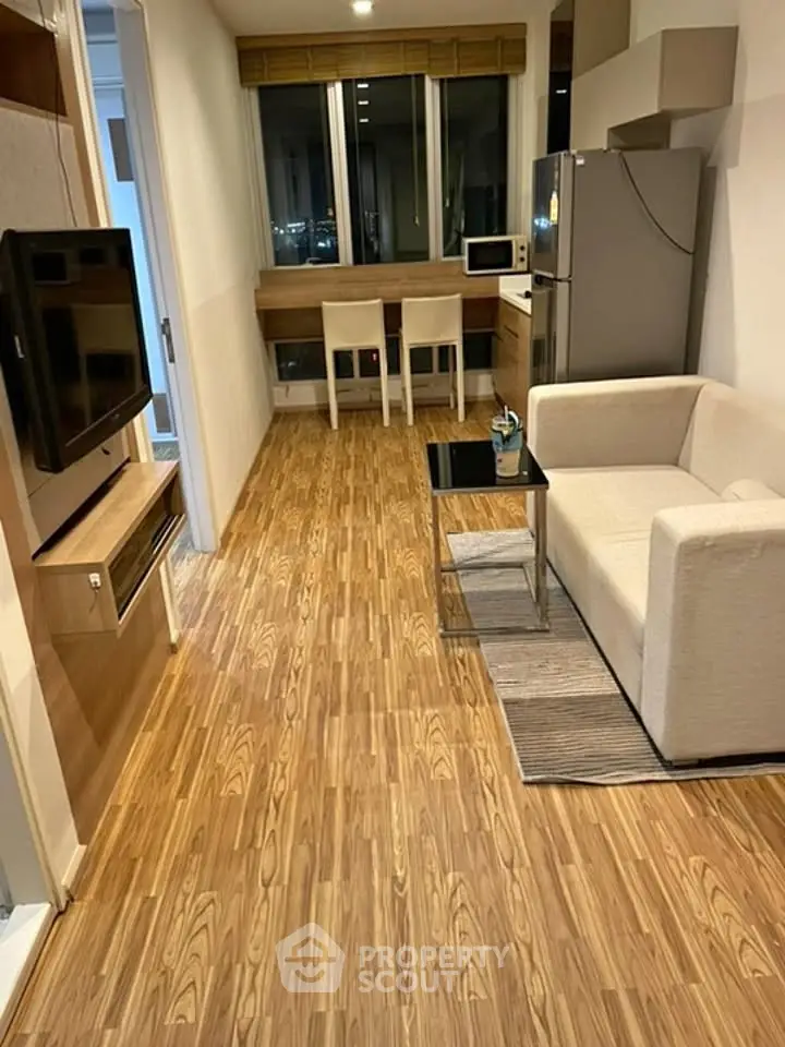 Modern apartment interior with cozy living area and kitchen, featuring wooden flooring and contemporary furniture.