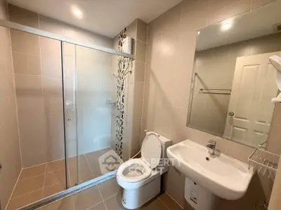 Modern bathroom with glass shower and sleek fixtures in a contemporary home.