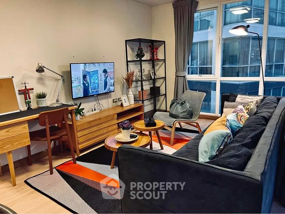 Modern living room with stylish decor and large window view in urban apartment.
