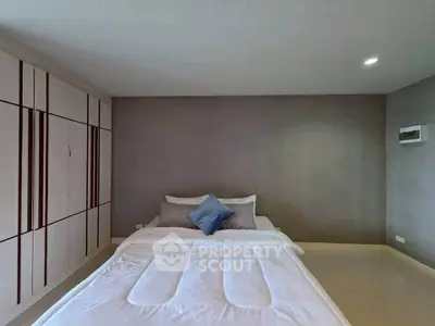 Spacious bedroom with modern design and ample storage in a stylish real estate property.