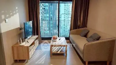 Modern living room with cozy sofa and city view balcony in high-rise apartment.
