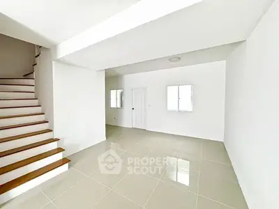 Spacious minimalist interior with sleek staircase and glossy tiled floors