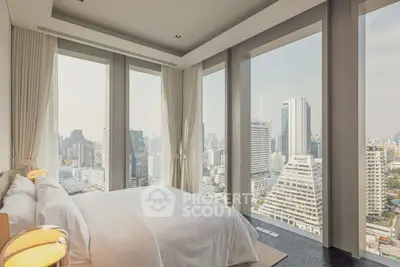 Luxurious bedroom with panoramic city views and floor-to-ceiling windows in a high-rise apartment.