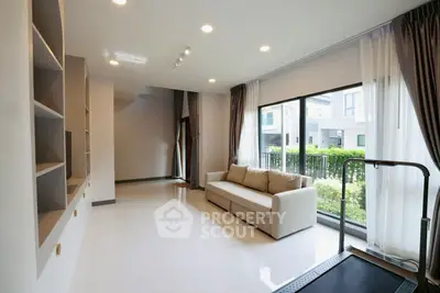 Spacious modern living room with treadmill and garden view, perfect for relaxation and fitness.