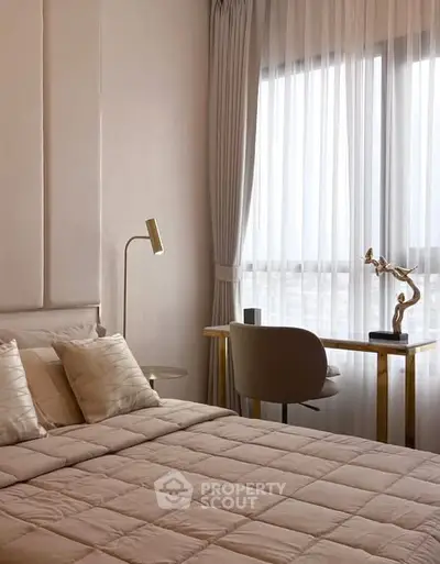 Elegant bedroom with modern decor and natural light through large window.