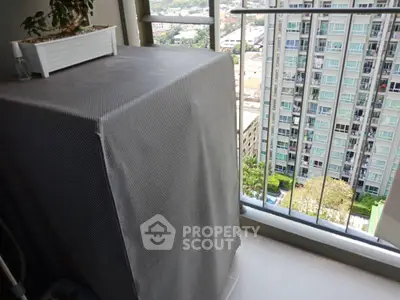 High-rise balcony with city view and covered appliance, ideal for urban living.
