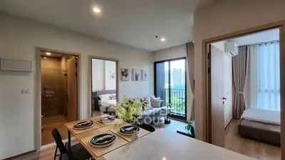 Modern apartment interior with open layout, featuring a cozy living room and dining area.