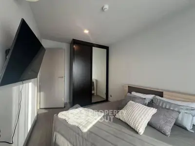 Modern bedroom with sleek design and wall-mounted TV, perfect for relaxation.