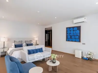 Spacious modern bedroom with elegant decor and cozy seating area