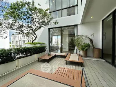 Modern outdoor patio with stylish furniture and lush greenery in a contemporary residential setting.