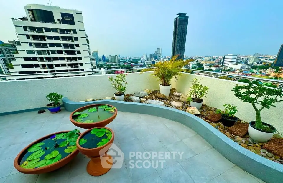 Stunning rooftop terrace with city skyline views and lush potted plants, perfect for urban relaxation.