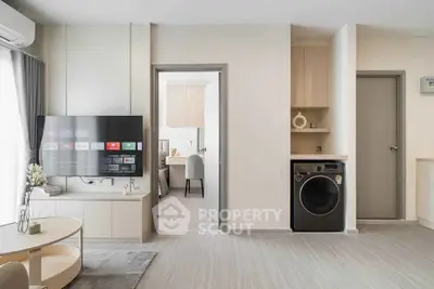 Modern living room with TV and washing machine in stylish apartment