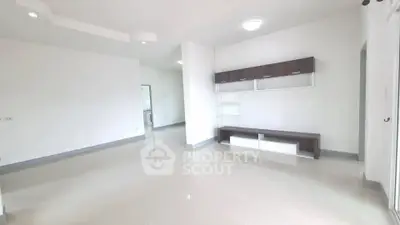 Spacious modern living room with sleek storage and bright lighting