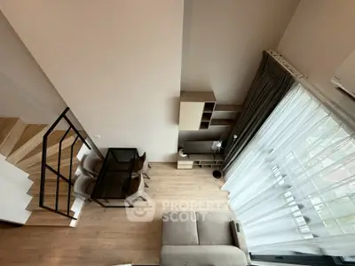 Modern loft apartment with stylish furniture and large windows offering natural light and a cozy atmosphere.
