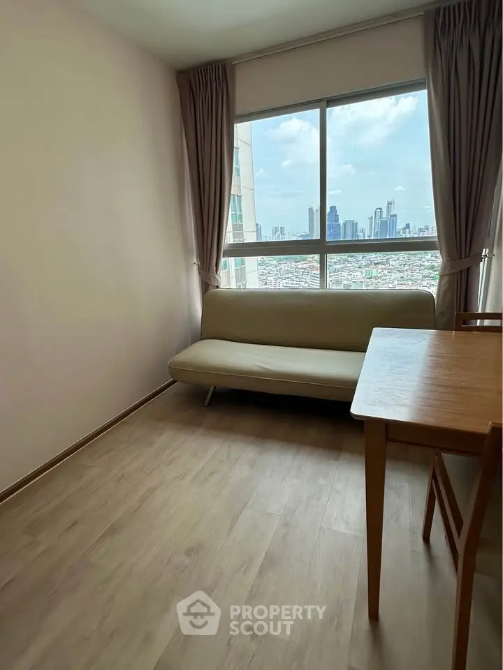 Bright living room with city view, featuring a cozy sofa and wooden dining table.