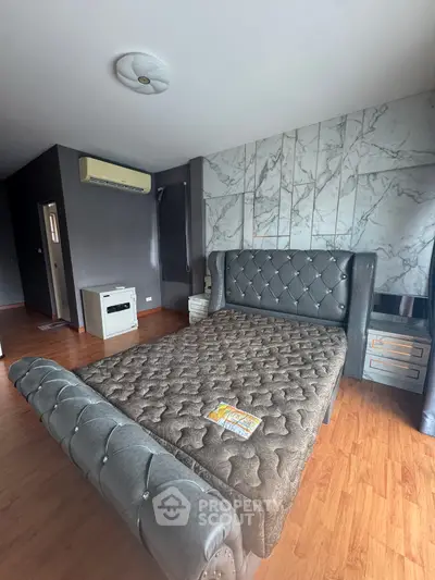 Luxurious bedroom with elegant bed and modern decor, featuring stylish wall design and wooden flooring.