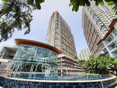 Luxurious high-rise residential complex with stunning pool and lush greenery.
