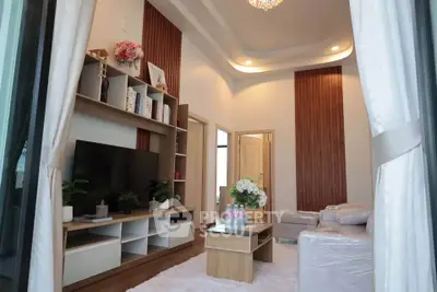 Elegant living room with modern decor, featuring a cozy seating area and stylish shelving unit.
