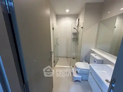 Modern bathroom with glass shower and sleek fixtures in a contemporary home.