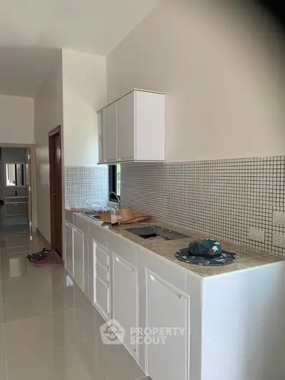 Modern kitchen with sleek white cabinets and tiled backsplash