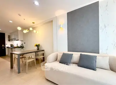 Modern living room with elegant dining area and stylish lighting in open-concept apartment.