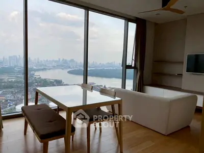 Stunning high-rise living room with panoramic city and river views, modern furniture, and floor-to-ceiling windows.