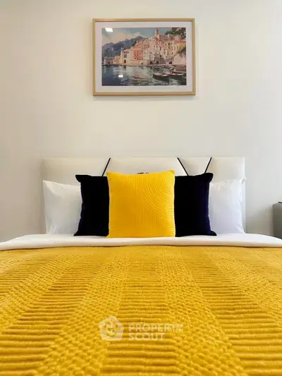 Stylish bedroom with vibrant yellow accents and elegant wall art, perfect for modern living.