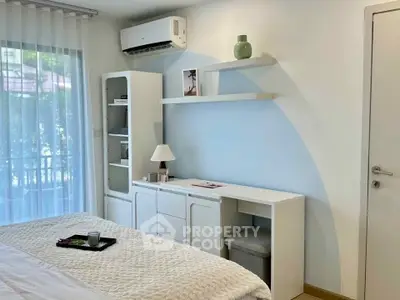 Modern bedroom with stylish furniture and natural light, featuring a cozy bed and elegant decor.