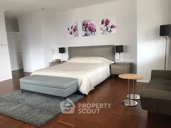 Spacious modern bedroom with elegant decor and hardwood flooring