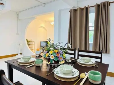 Elegant dining area with stylish table setting and floral centerpiece in modern apartment.