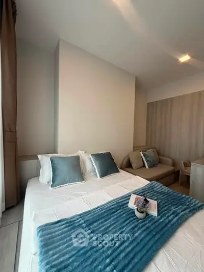 Modern bedroom with cozy decor and stylish blue accents in a contemporary apartment.