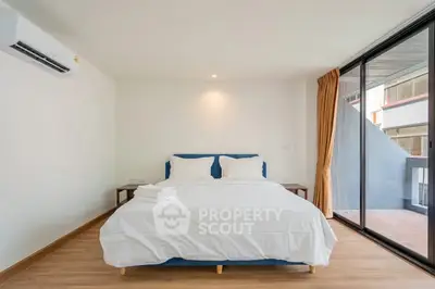 Spacious bedroom with large window and modern decor