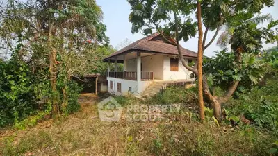 Charming rustic house surrounded by lush greenery, offering serene and private living in a natural setting.