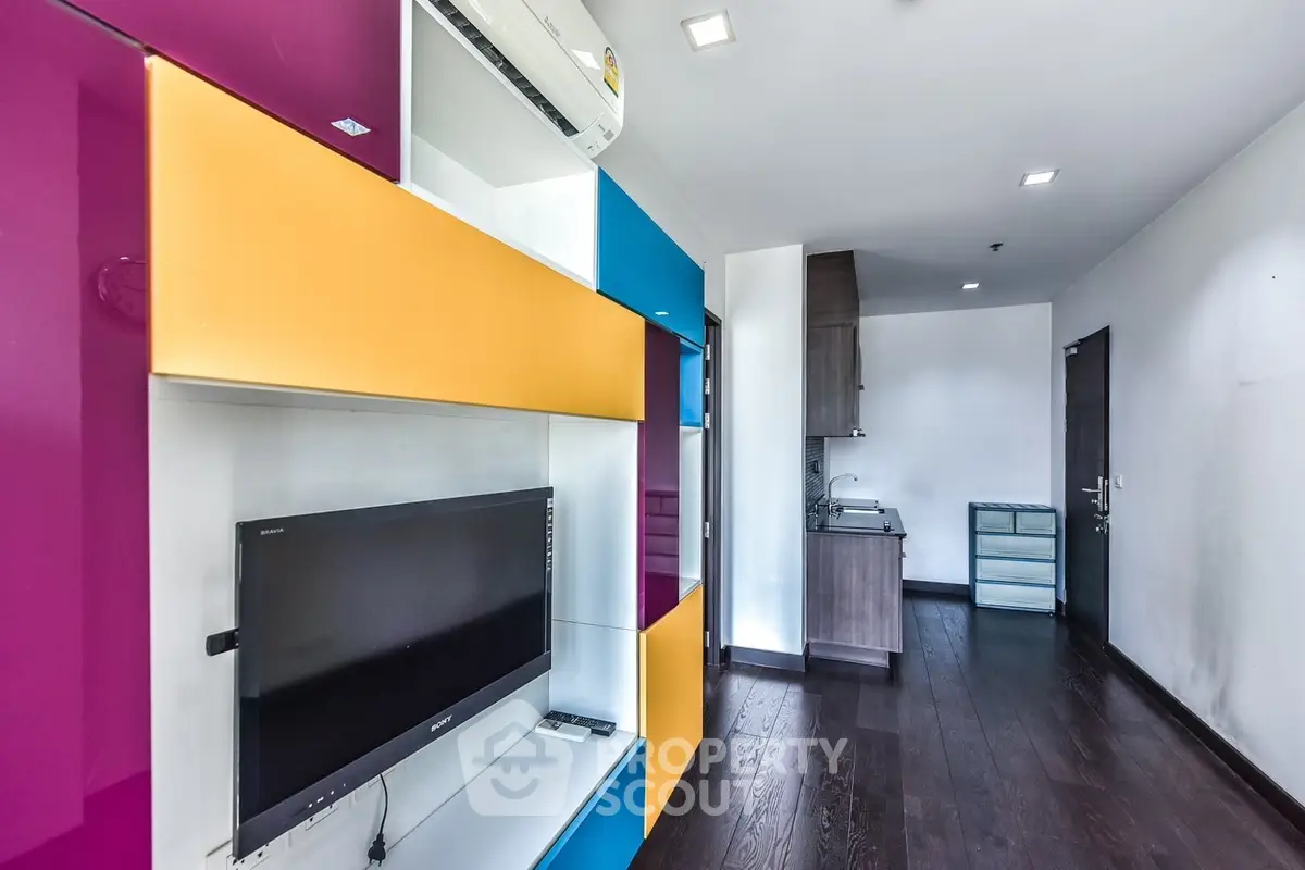 Modern apartment interior with colorful shelving and sleek kitchen design