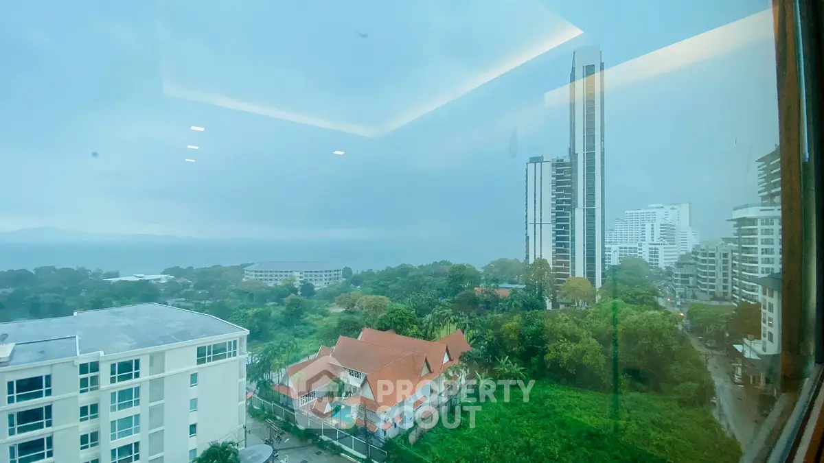 Stunning cityscape view from high-rise building window on a rainy day.