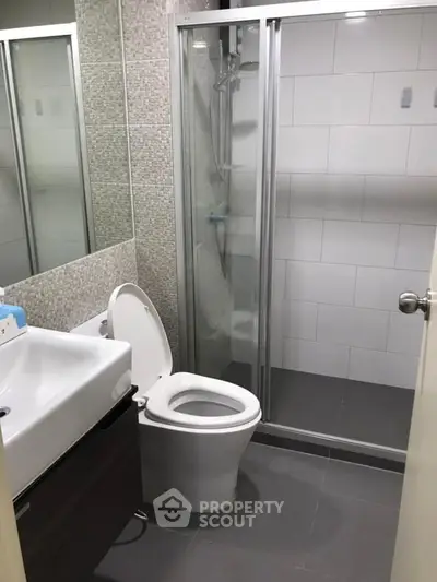 Modern bathroom with sleek shower and contemporary fixtures in a stylish apartment.