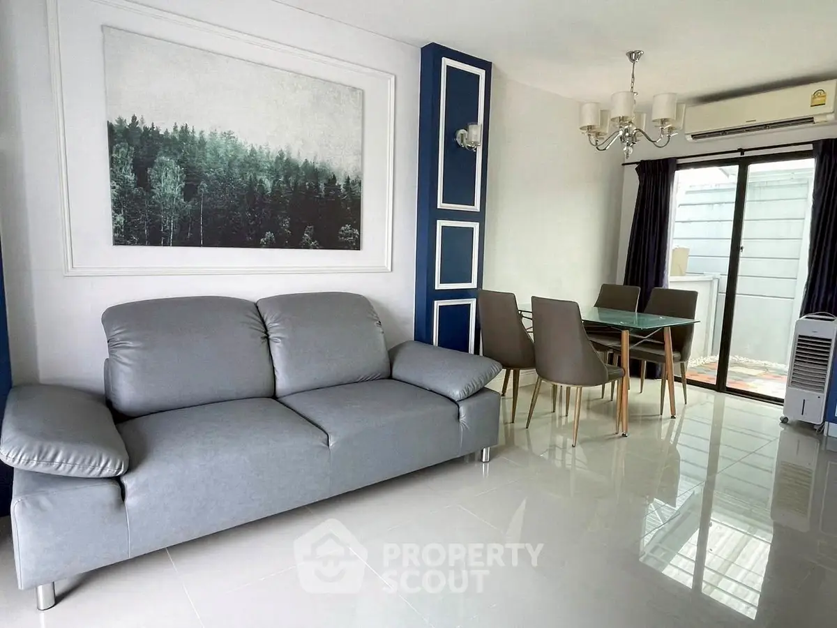 Modern living room with sleek gray sofa and elegant dining area