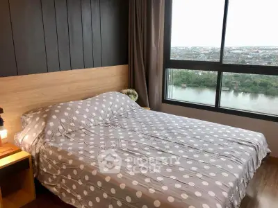 Cozy bedroom with large window offering stunning river view, perfect for relaxation and comfort.