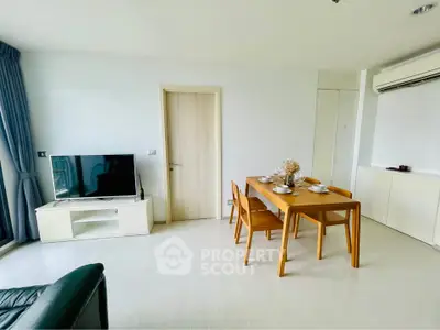 Modern living room with dining area, TV, and air conditioning in a bright apartment.