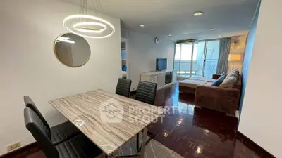 Modern living room with stylish dining area and cozy seating, featuring elegant lighting and a balcony view.