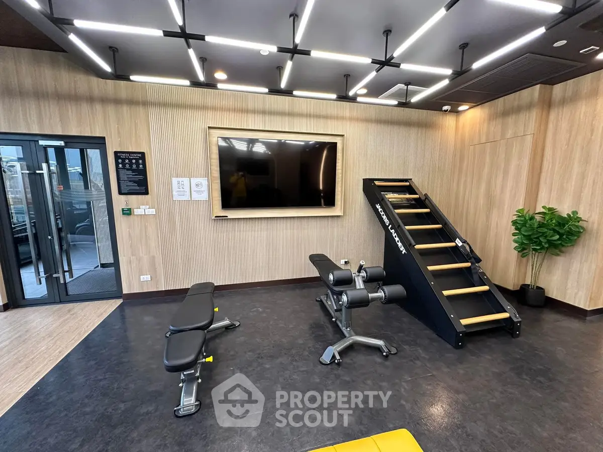 Modern gym with sleek equipment and stylish lighting in a luxury building.