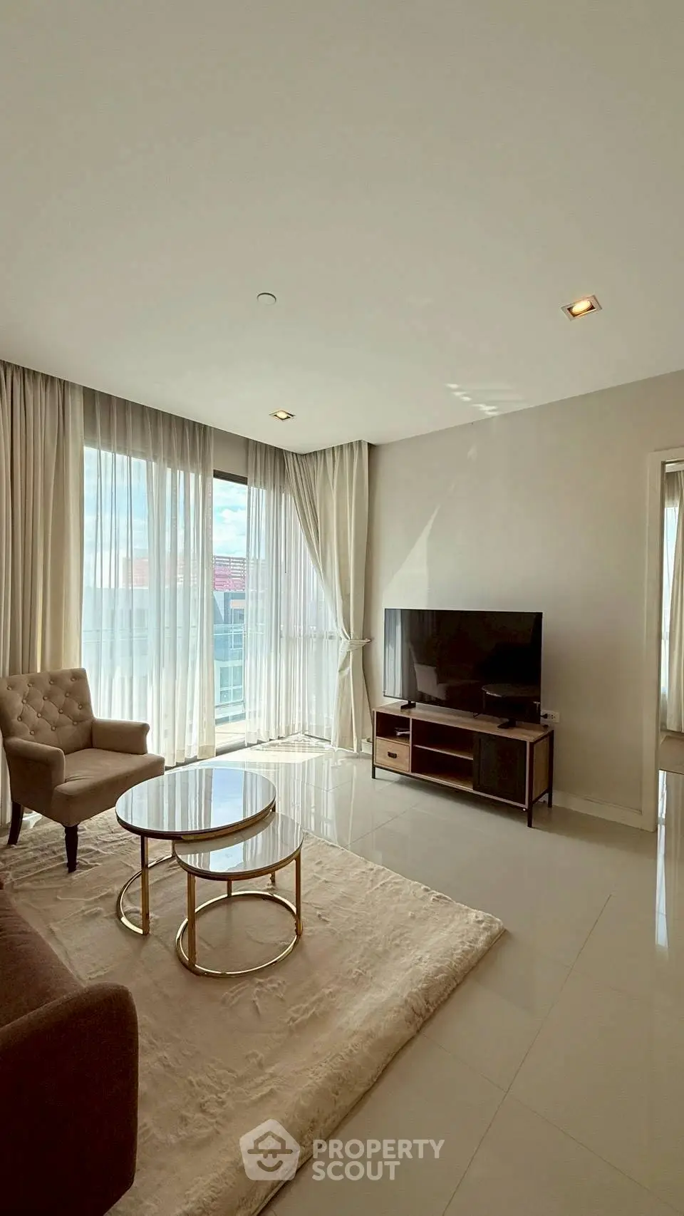 Spacious living room with modern furniture and large windows offering natural light.