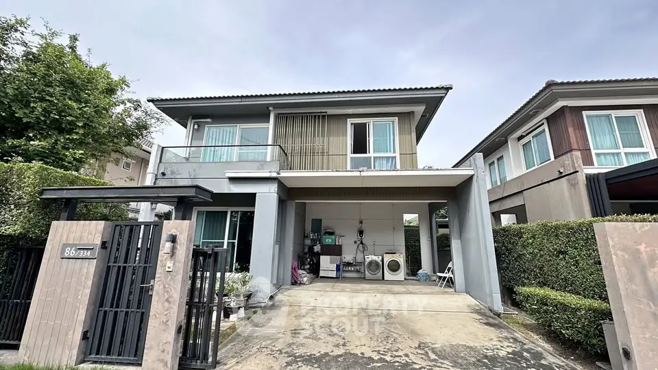 Modern two-story house with driveway and lush greenery