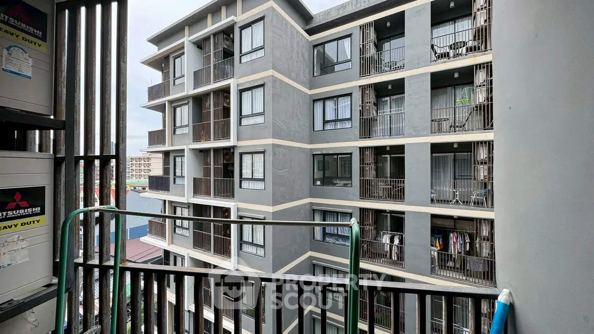 Modern apartment building exterior with balconies and urban view.