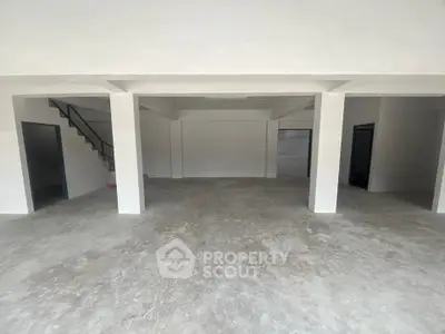 Spacious open-plan interior with concrete flooring and modern design, ideal for versatile use.
