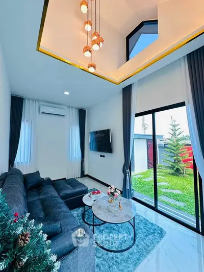 Modern living room with stylish decor, large windows, and garden view.