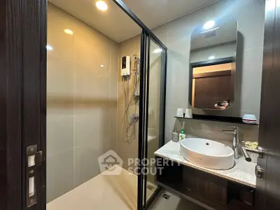 Modern bathroom with sleek shower and stylish vanity in contemporary apartment.