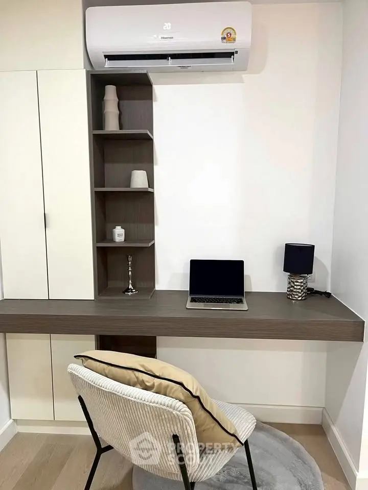 Modern study area with sleek desk, laptop, and air conditioning unit.