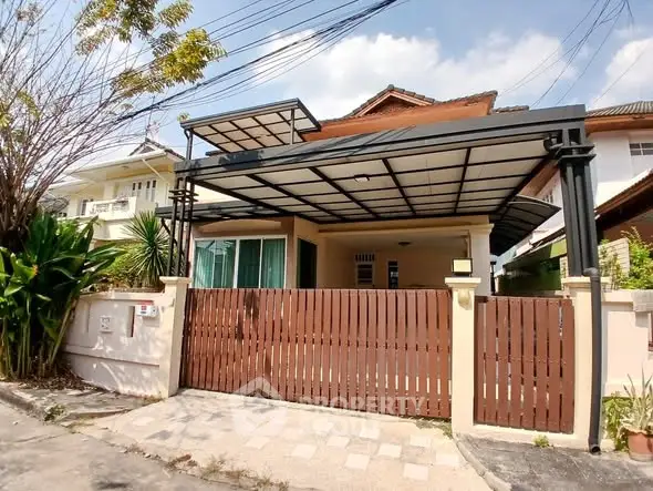 Charming suburban house with covered carport and wooden gate in a peaceful neighborhood.
