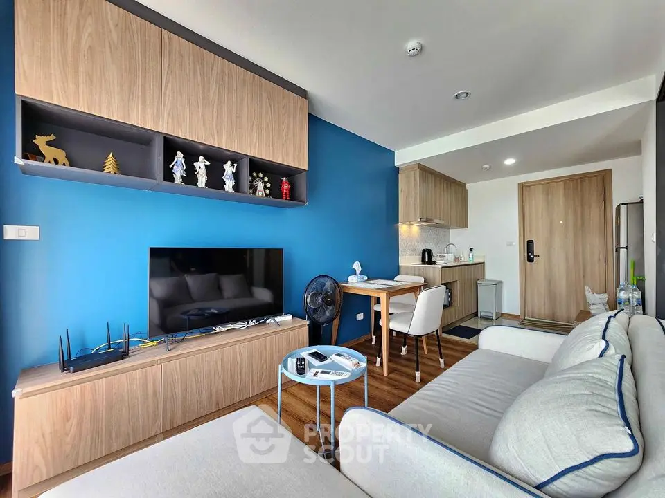 Modern living room with stylish blue accent wall and open kitchen layout